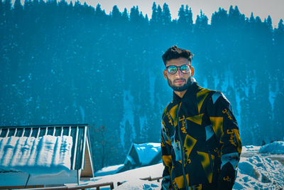 Portrait of young man standing in snow