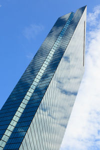 Low angle view of modern building against blue sky