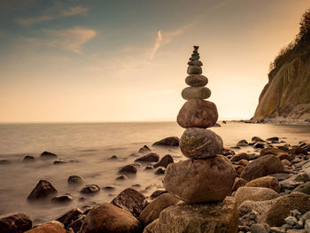 Stack of stones on ruegen island beach. rounded pebbles stack in peaceful evening with smooth ocean 