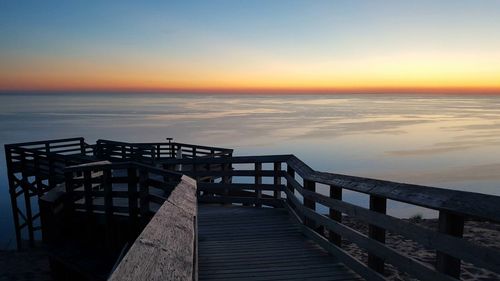 Pier on sea at sunset