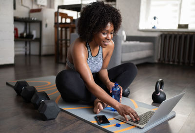 Black sportswoman using laptop during break