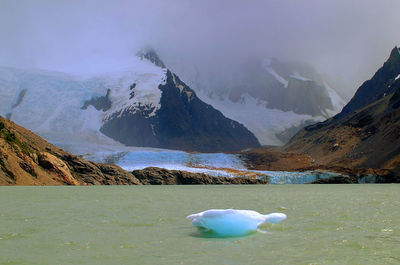 Scenic view of frozen lake and mountains against sky