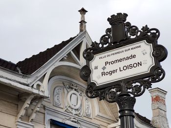 Low angle view of text on building against sky