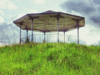 View of grassy field against cloudy sky