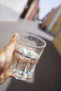 Close-up of hand holding glass of water