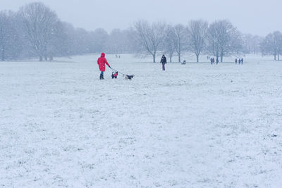 People playing on snow covered field