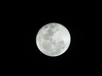 Low angle view of full moon against black sky