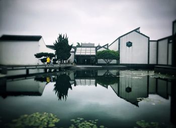 Reflection of building in lake against sky