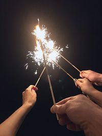 Close-up of hand holding sparkler at night