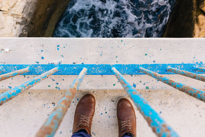 Low section of man standing on bridge over river