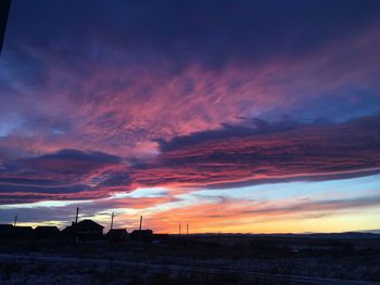 Scenic view of dramatic sky over land during sunset