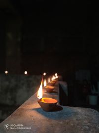 Close-up of lit candles burning at night