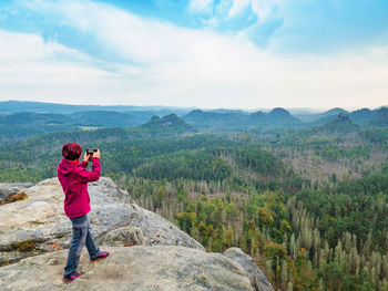 Travel hike woman hiker taking photo with phone of landscape of trail hiking in autumn landscape