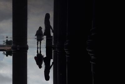 Silhouette women reflection in floor against sky