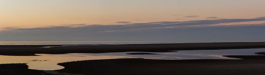 Scenic view of beach against sky during sunset