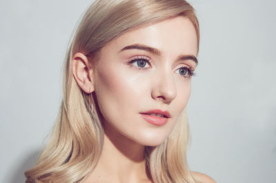 Close-up of young woman against white background