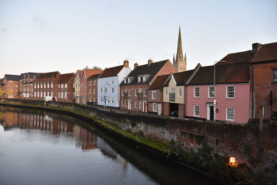 Canal amidst buildings in town against sky