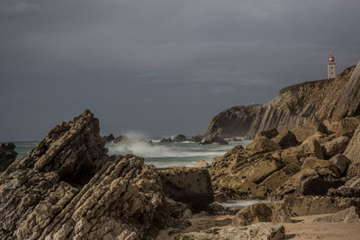 Rock formations by sea against sky