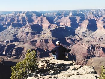 Rear view of man sitting at grand canyon national park