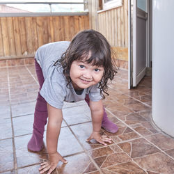 Portrait of smiling girl standing on tiled floor