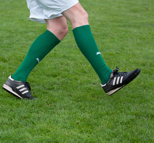 Low section of man with umbrella on field