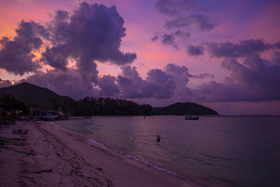 Scenic view of beach against sky at sunset