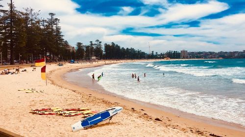 Panoramic view of people on beach against sky