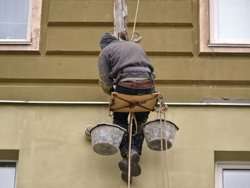 Low angle view of man working by building