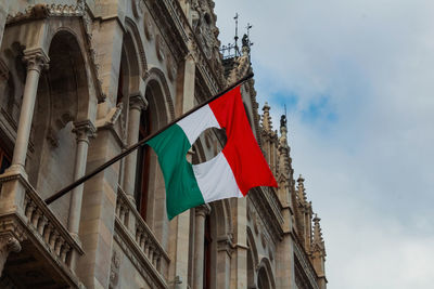 Low angle view of hungary flag with central hole on budapest parliament