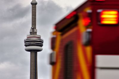 Low angle view of communications tower in city against sky