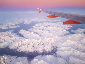 Aerial view of airplane wing over clouds