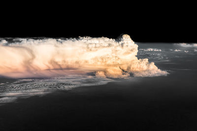 Waves on beach against sky during sunset