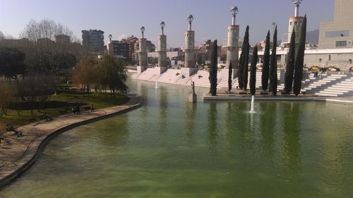 River by buildings against sky in city