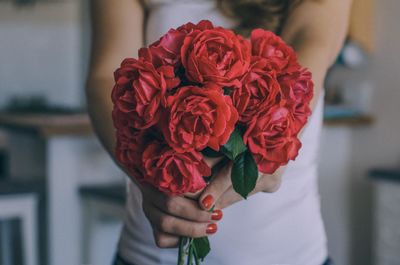 Midsection of woman holding red rose bouquet