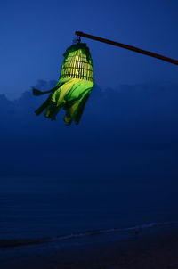 Lamp hanging by sea against clear blue sky