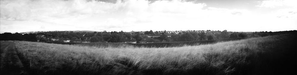 Scenic view of field against cloudy sky