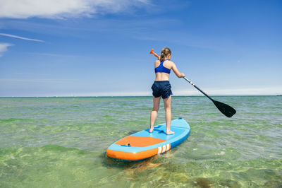 Man standing in sea against sky