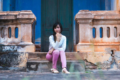 Portrait of woman standing against pink wall