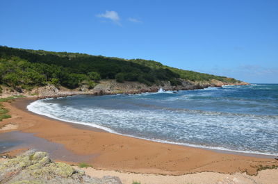 Scenic view of beach against blue sky