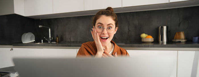 Portrait of young man using mobile phone while sitting at home