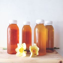 Close-up of flower in jar on table against wall