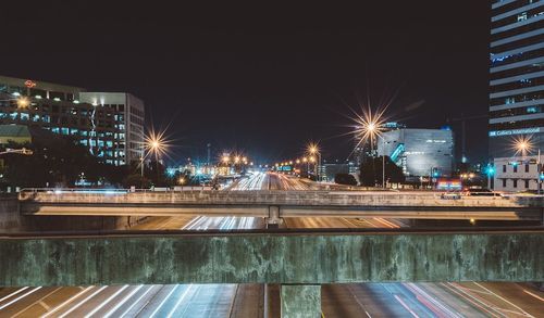 Illuminated light trails in city against clear sky at night