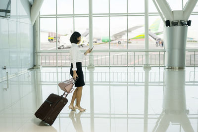 Woman holding umbrella standing at airport