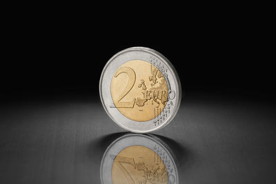 Close-up of coins on table against black background