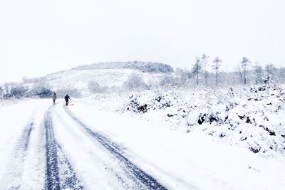 Tourists on snow covered mountain