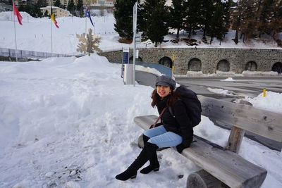 Full length of woman sitting on snow