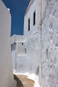 Alley amidst buildings against clear sky