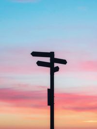 Silhouette cross against sky during sunset