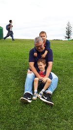 Full length of father and son on grassland