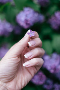 Hand holding a rare find - five petal syringa that is believed to bring luck to its finder.